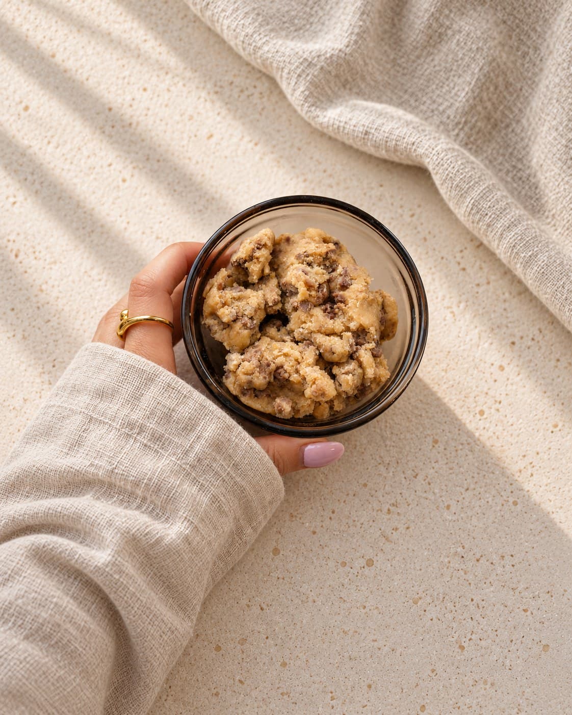 En hånd holder en glassbolle med Old Mill cookie dough